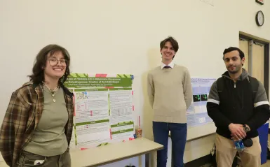 Students at NHCC+ standing next to their research poster 