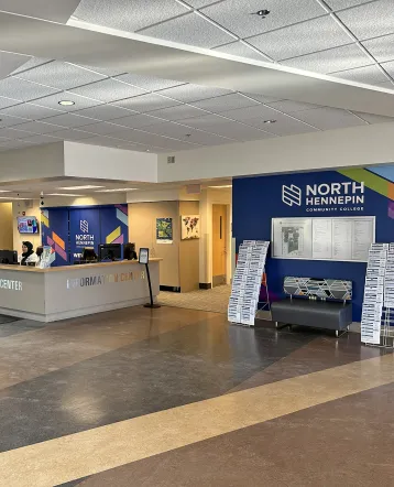 front desk area with signage and a person at the desk