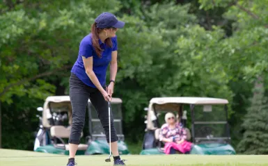 woman about to hit a golf ball 