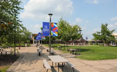 Campus courtyard with picnic tables and branded banners