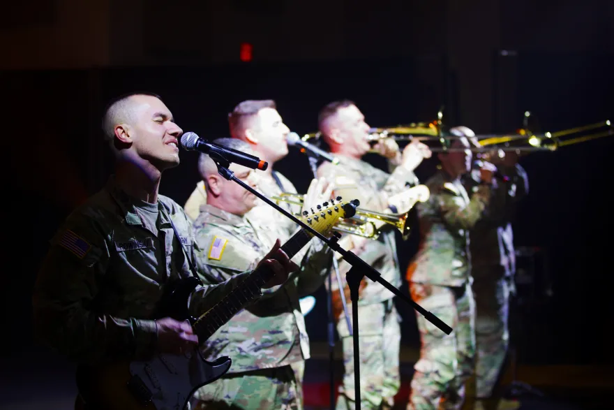 NHCC's Veteran Services Coordinator, Dylan Rowinski, singing and playing guitar with his MN Army National Guard group