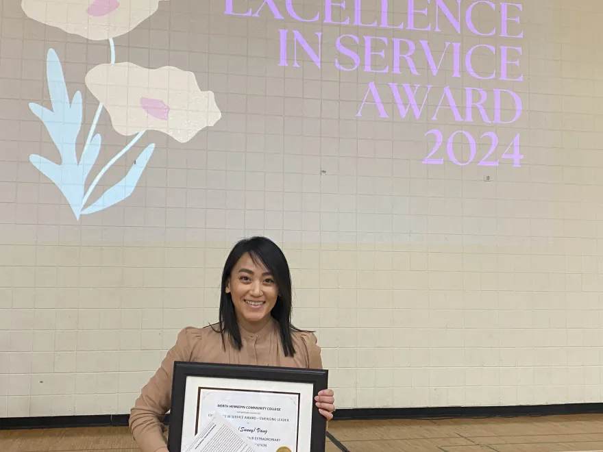 NHCC employee, Nou (Sunny) Vang holding her excellence in service award