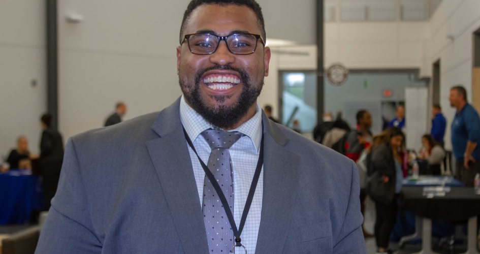 alumni Dante Willams standing in front of a NHCC career fair