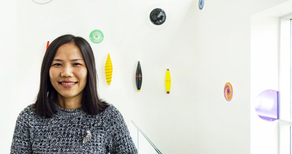 computer science student standing inside art decorated hallway smiling at the camera
