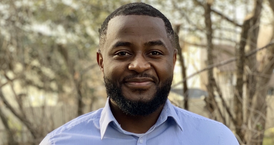 STEM alumni Alain Njipwo outside smiling at camera