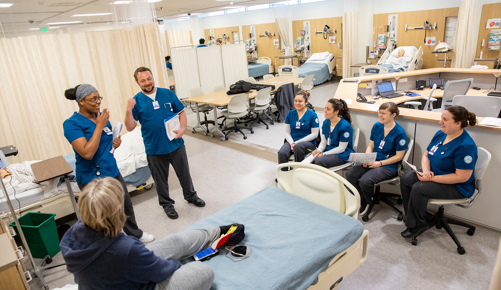 students in a nursing lab in a group talking