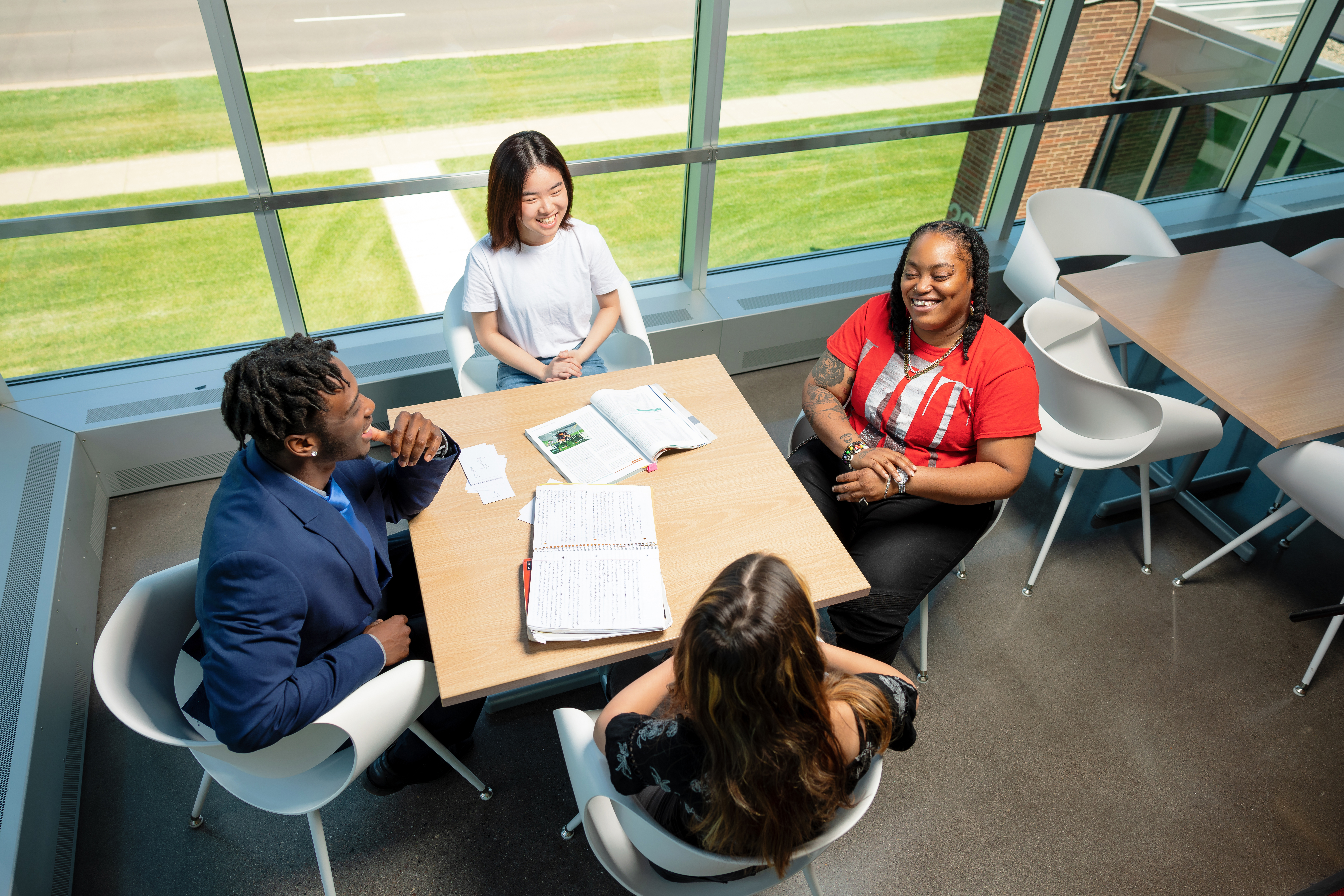 photo of four students studying at a hallway table