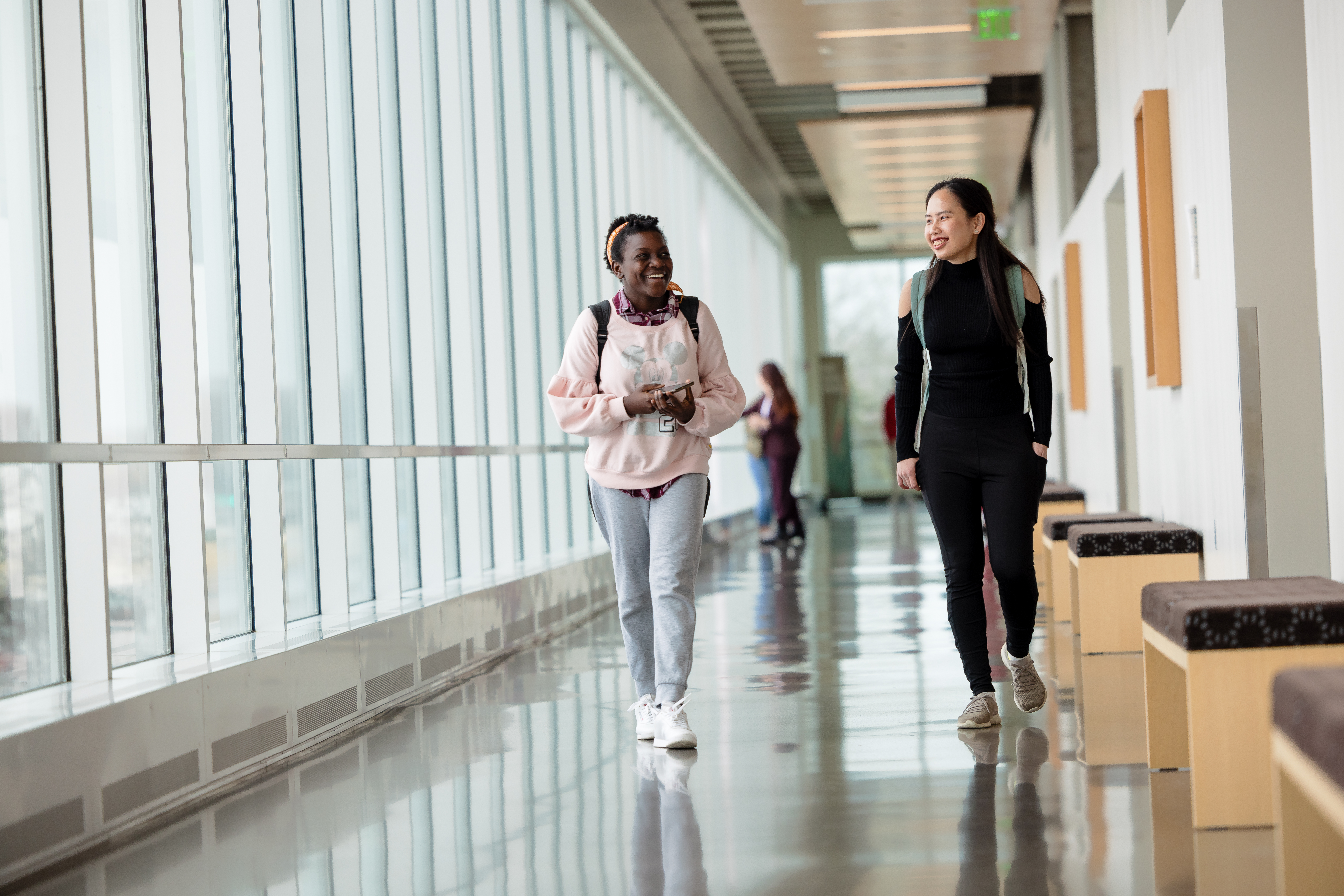 a photo of two NHCC alumni students walking in the hall