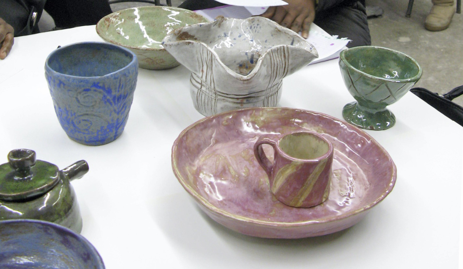 colorful ceramic bowls and mugs on a table