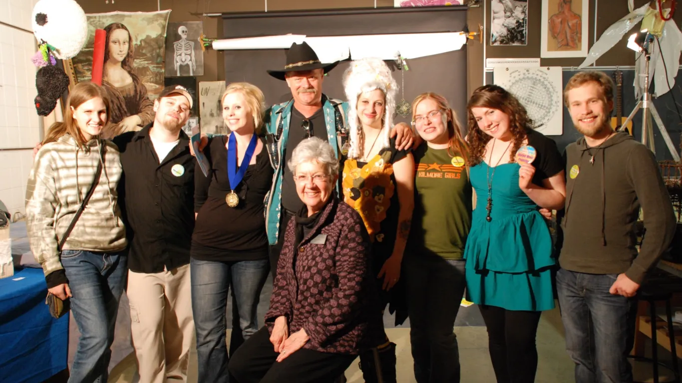 students and instructors smiling in an art studio 