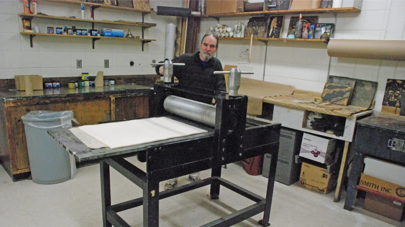 art instructor standing near a printing press 