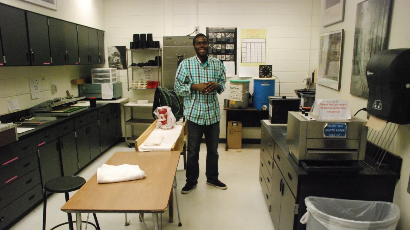 student standing in an art lab smiling 