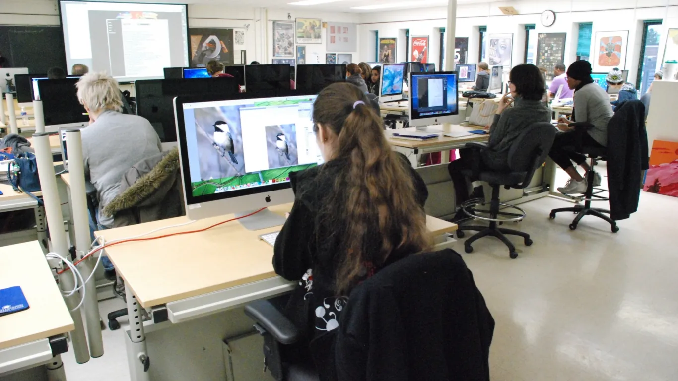 students in an art classroom working on macs