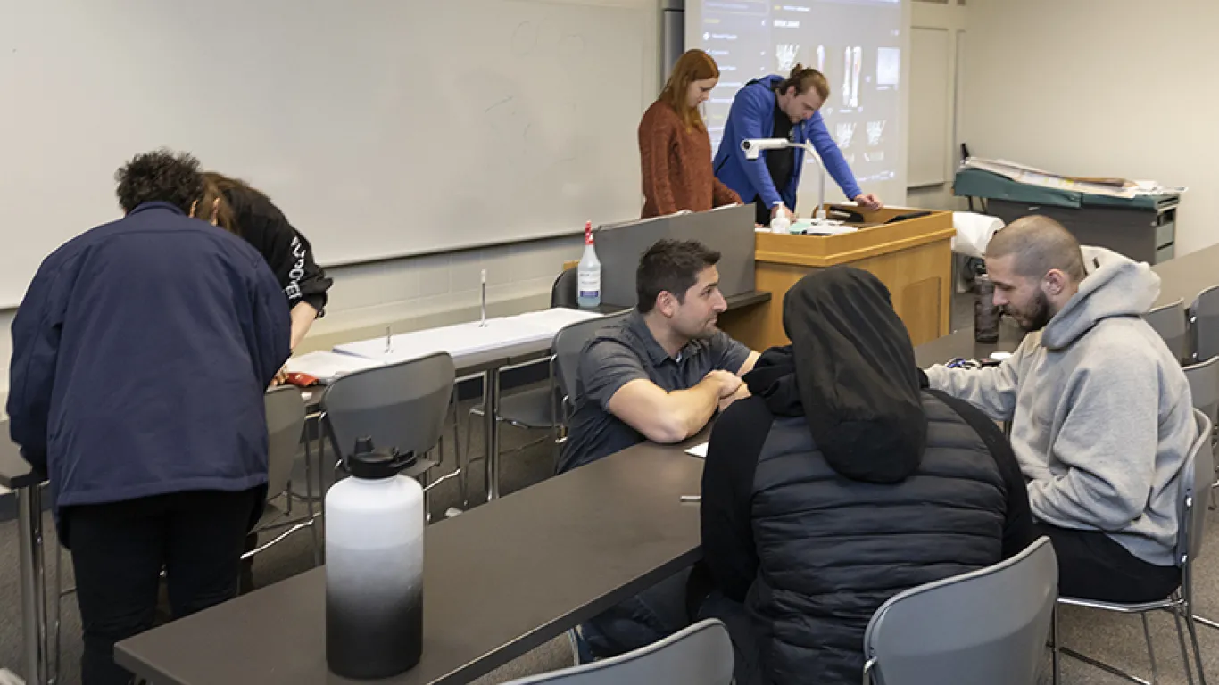 instructor working with students in a classroom 