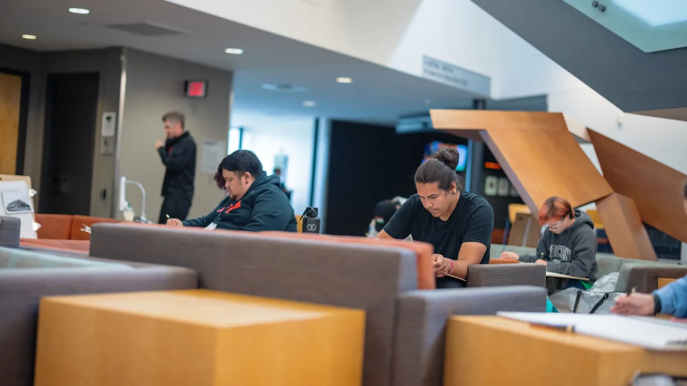 students working on a project in a lounge area