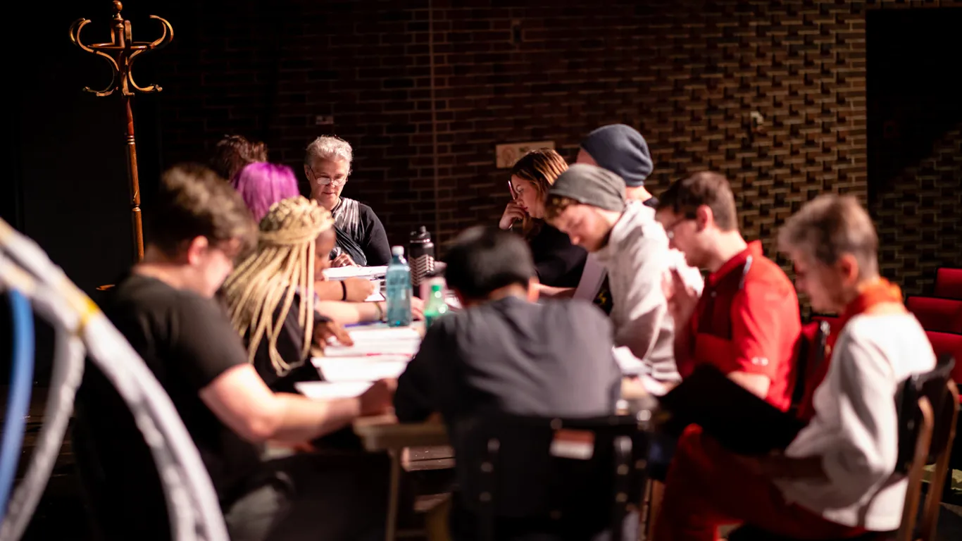 students at a table on a theater stage