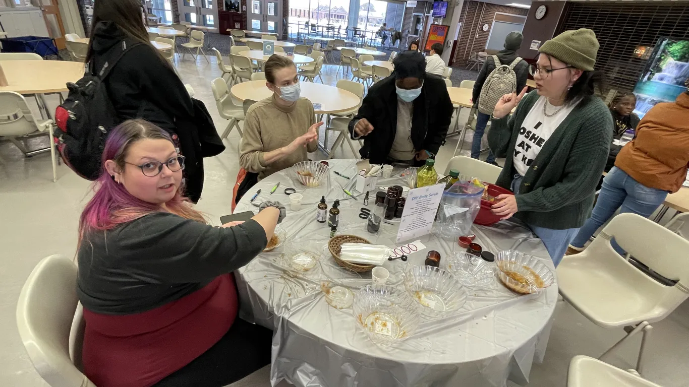 students sitting at table creating sugar scrubs
