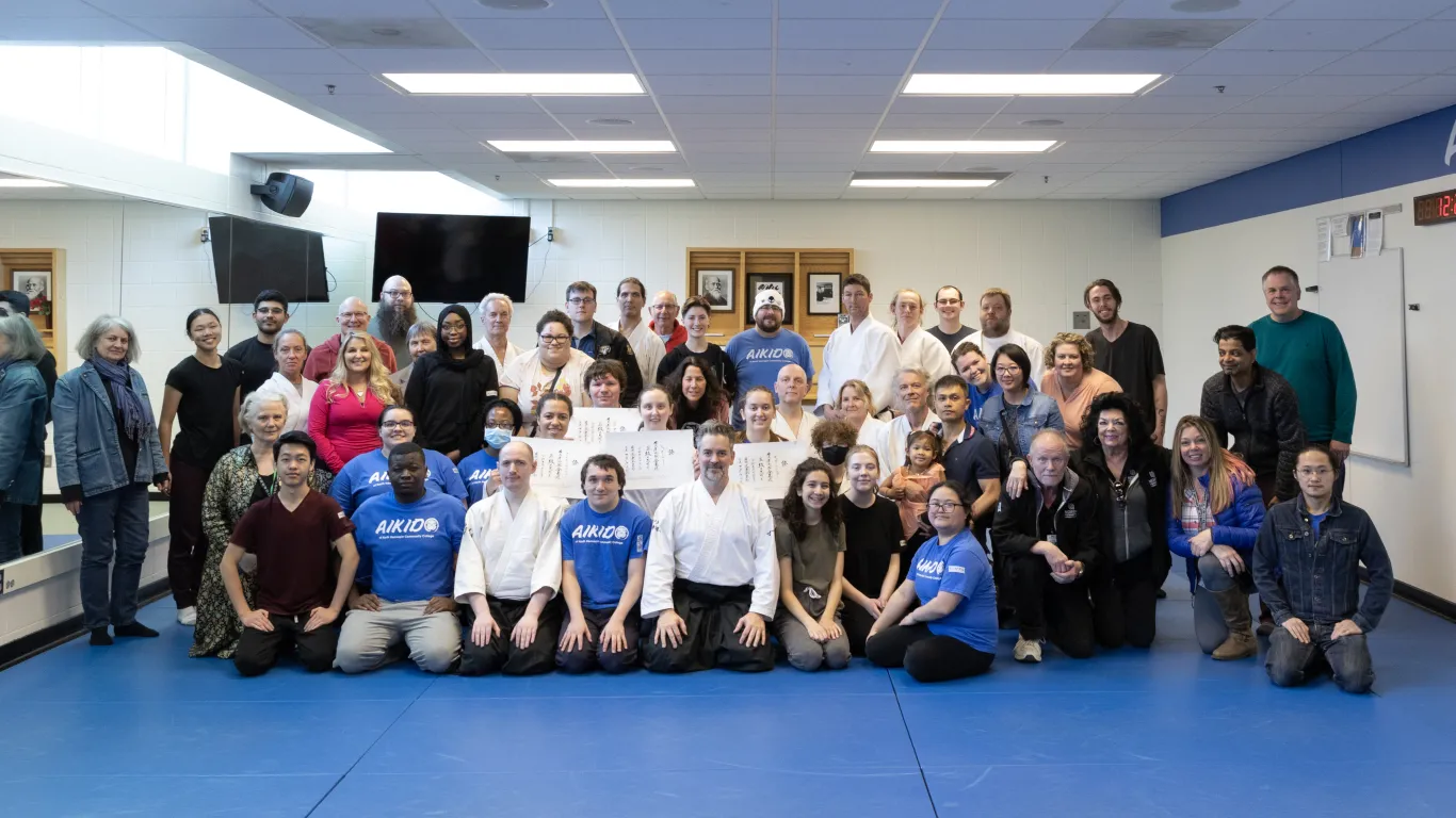 large group of people kneeling and standing in a studio