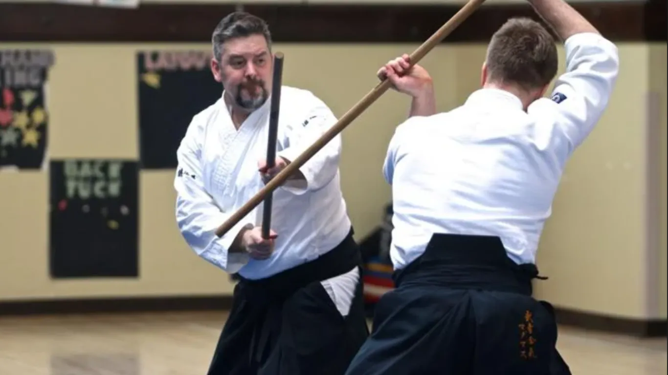 two men using wooden swords 