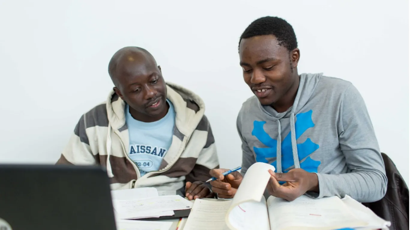 students working together at a table with a laptop