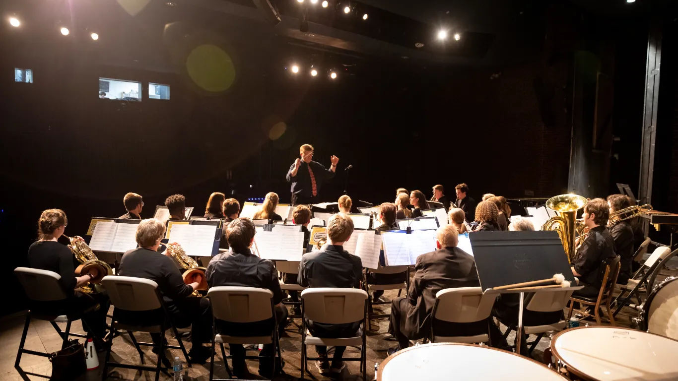 band performing on stage with audience in the background 