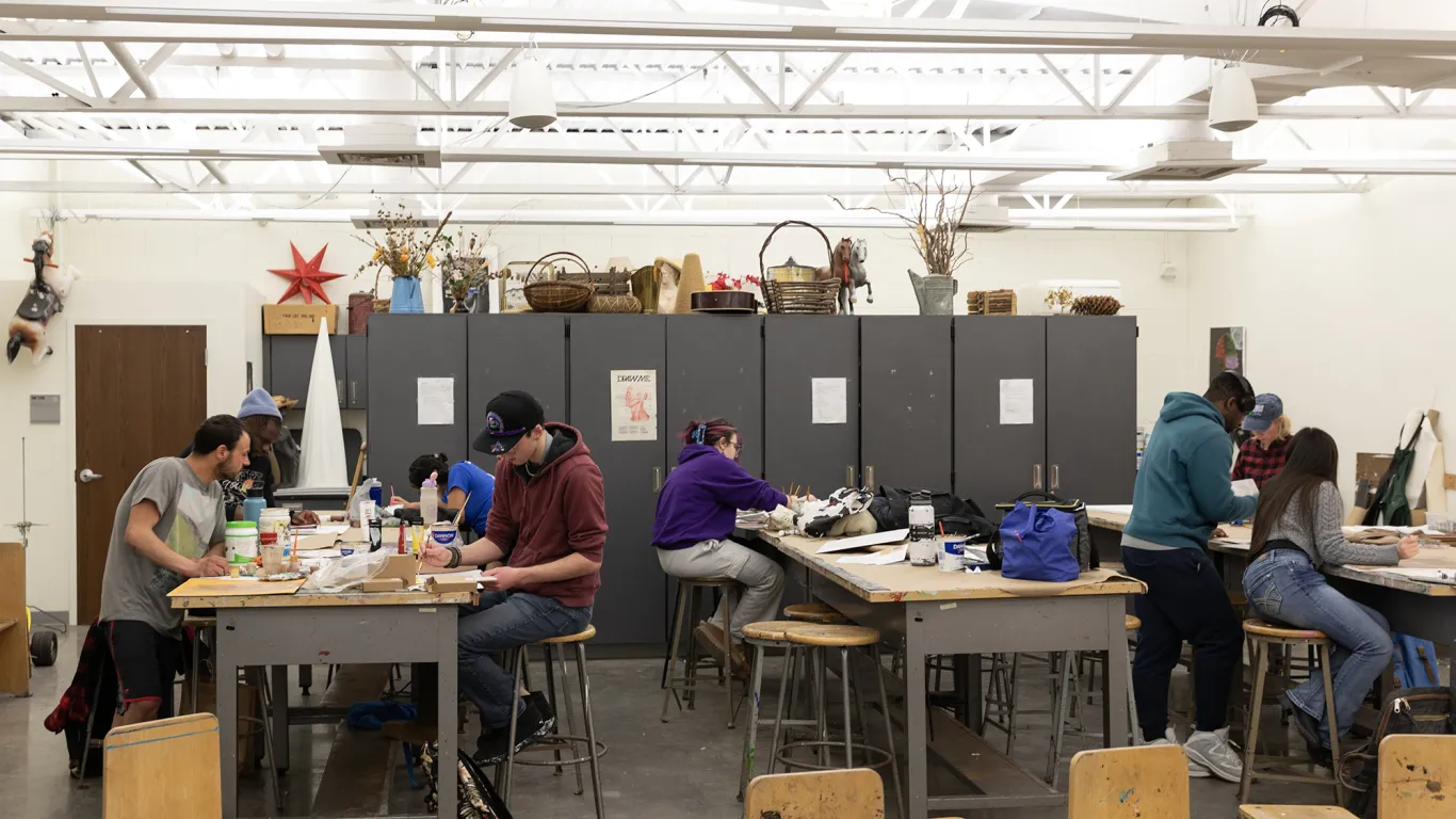 students at table painting in an art class