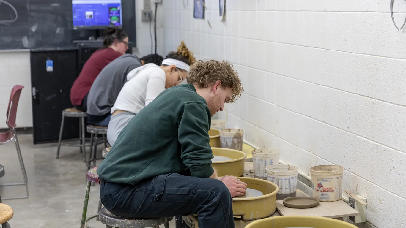 students at pottery wheels 
