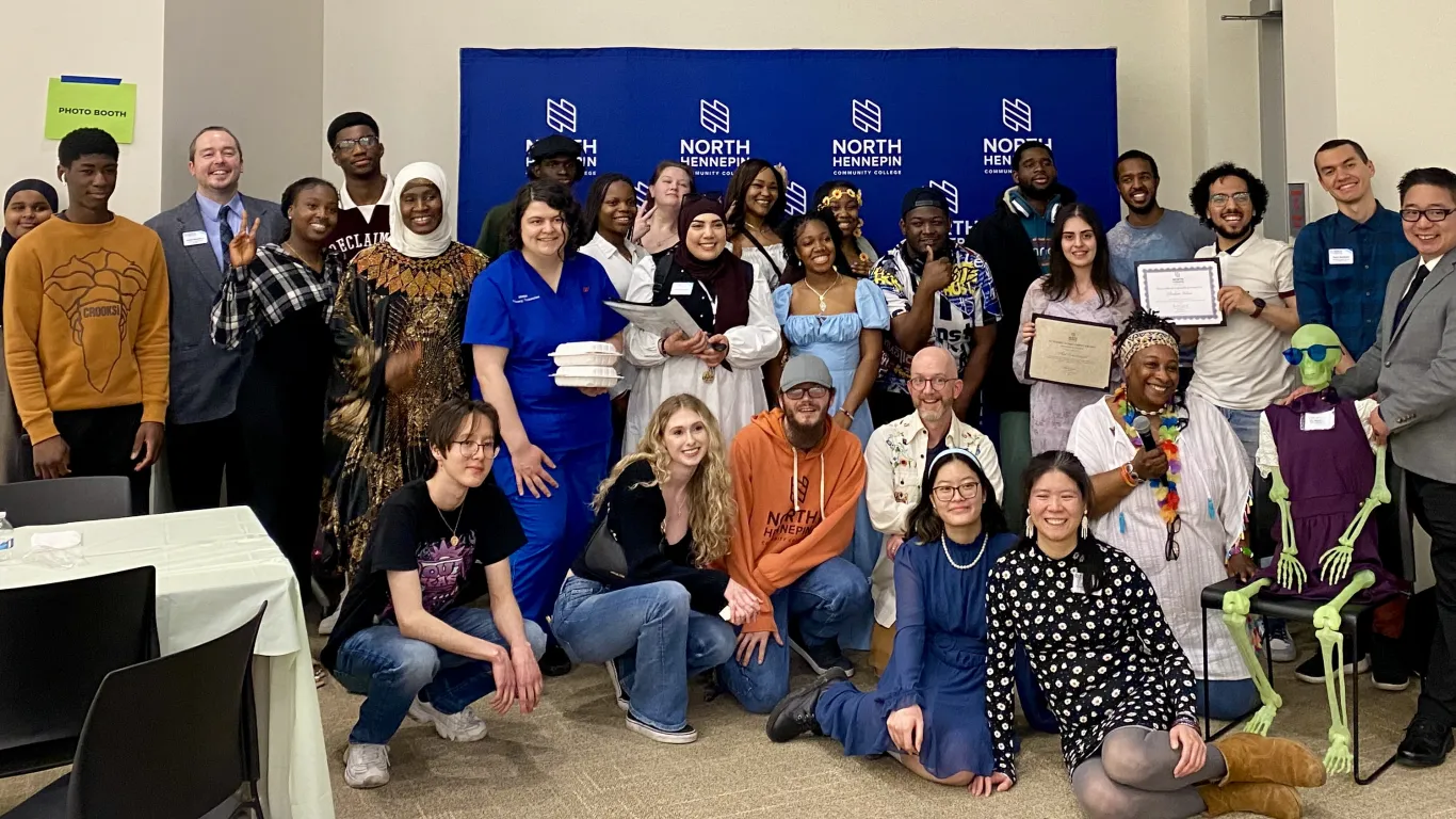This is a group photo of various students and staff who attended the Student Life Awards Banquet. The group piled together for a photo in front of the NHCC logo backdrop. 