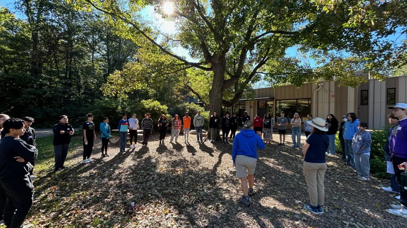 students standing outside in a large circle 