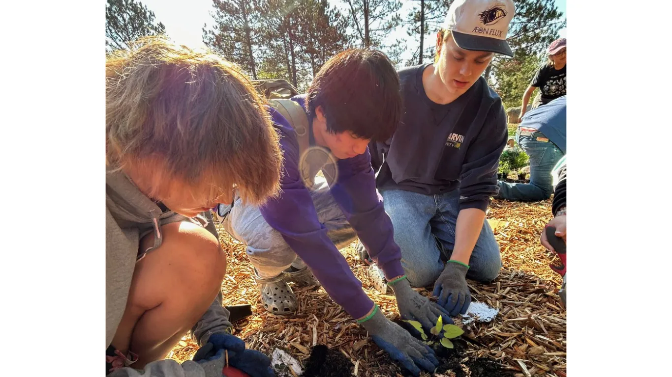 students planting seeds outside