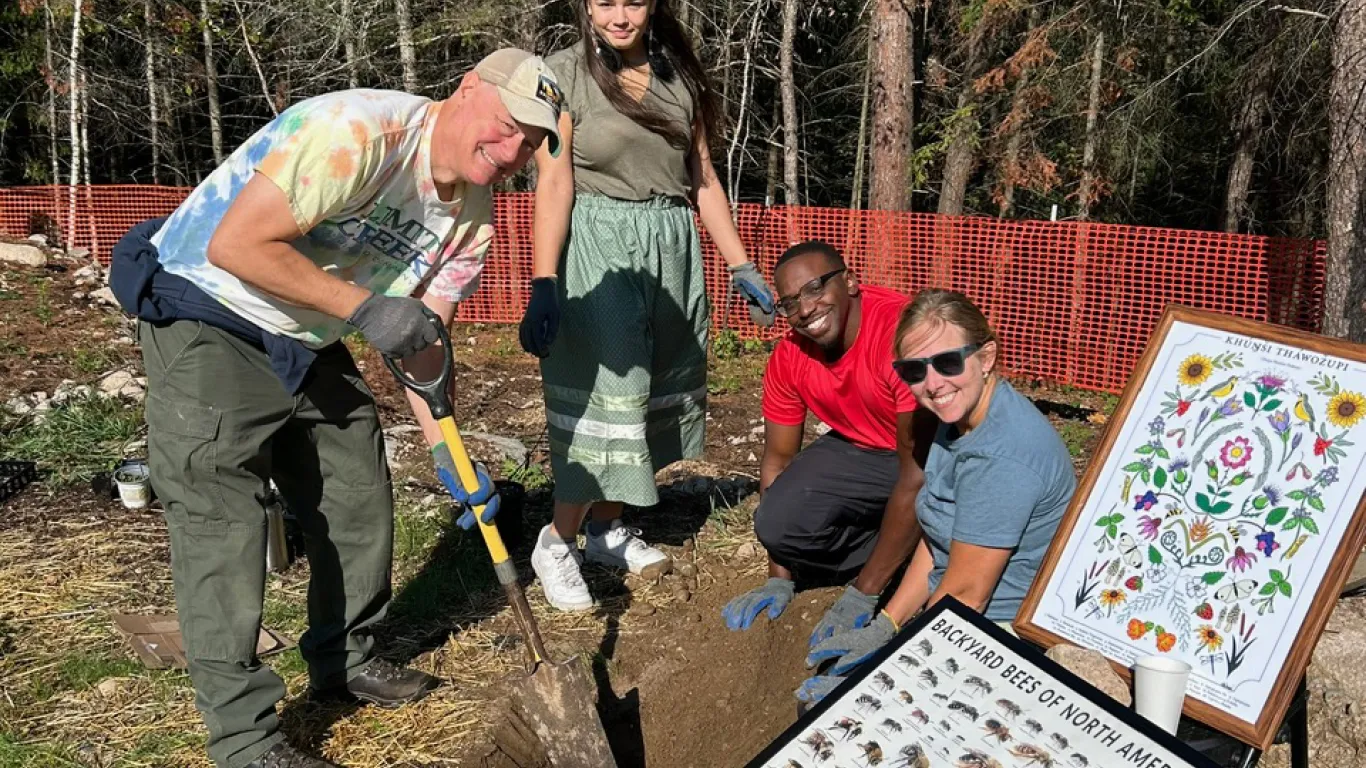 students digging in dirt outside with an instructor 