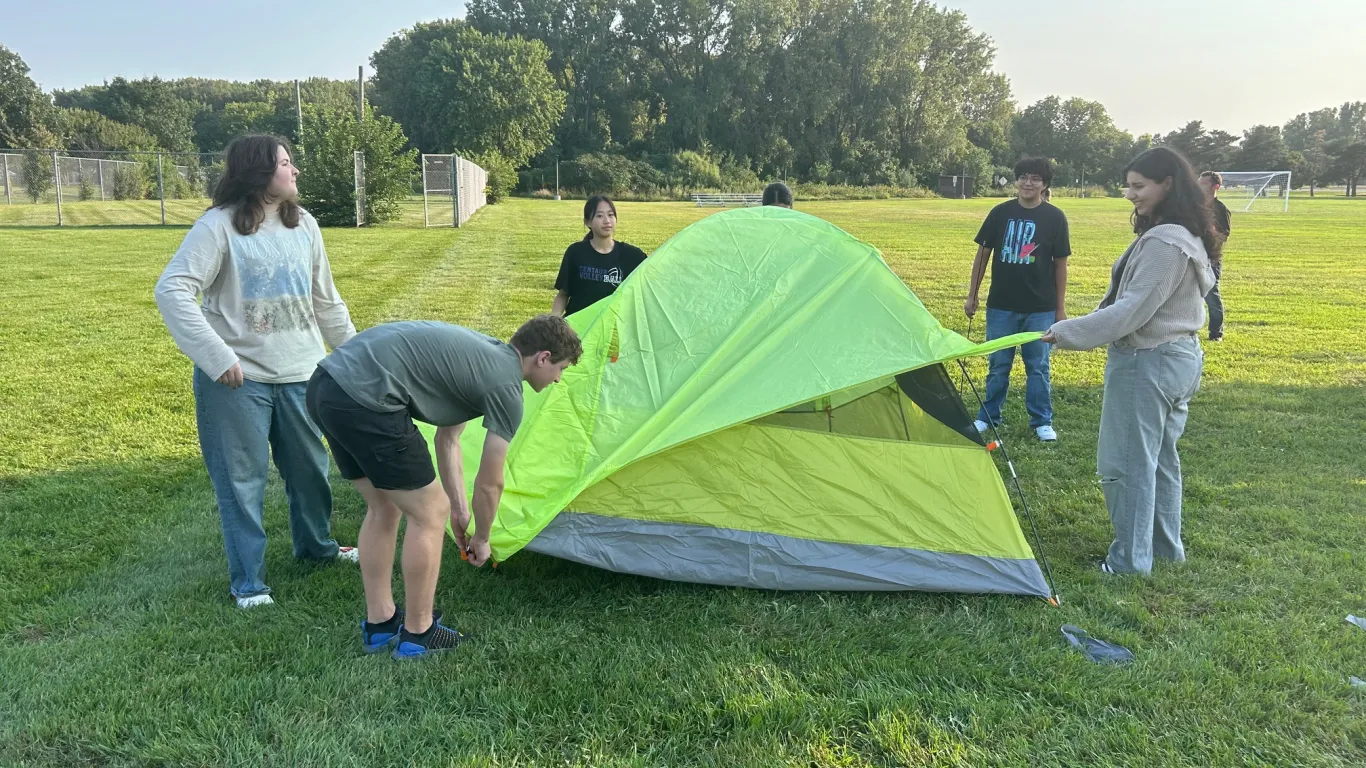 students putting together a tent 