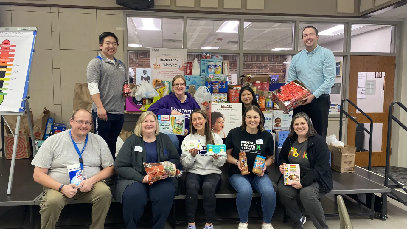 group of people holding food/paper items from the Food Drive