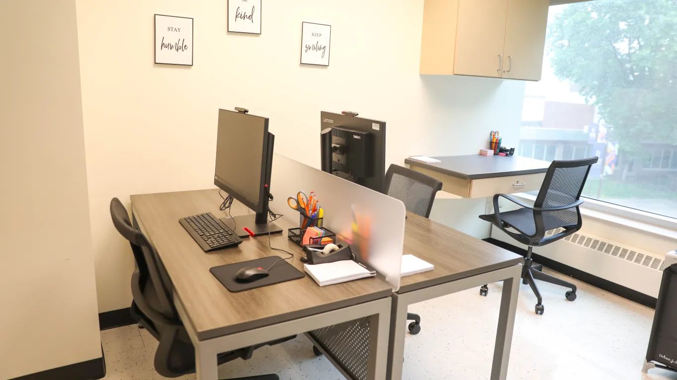 tables and computers in a room with a window