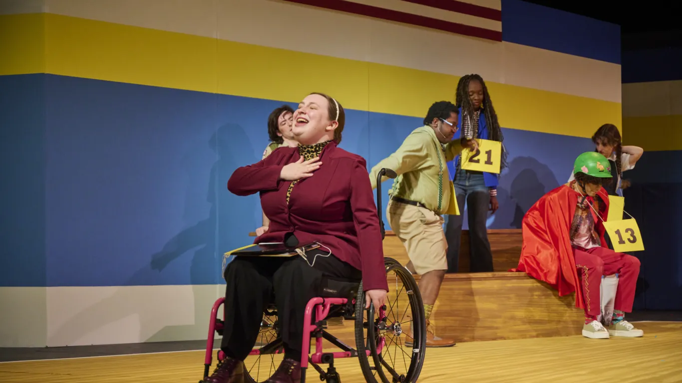 An actor performing on stage in the musical “The 25th Annual Putnam County Spelling Bee”