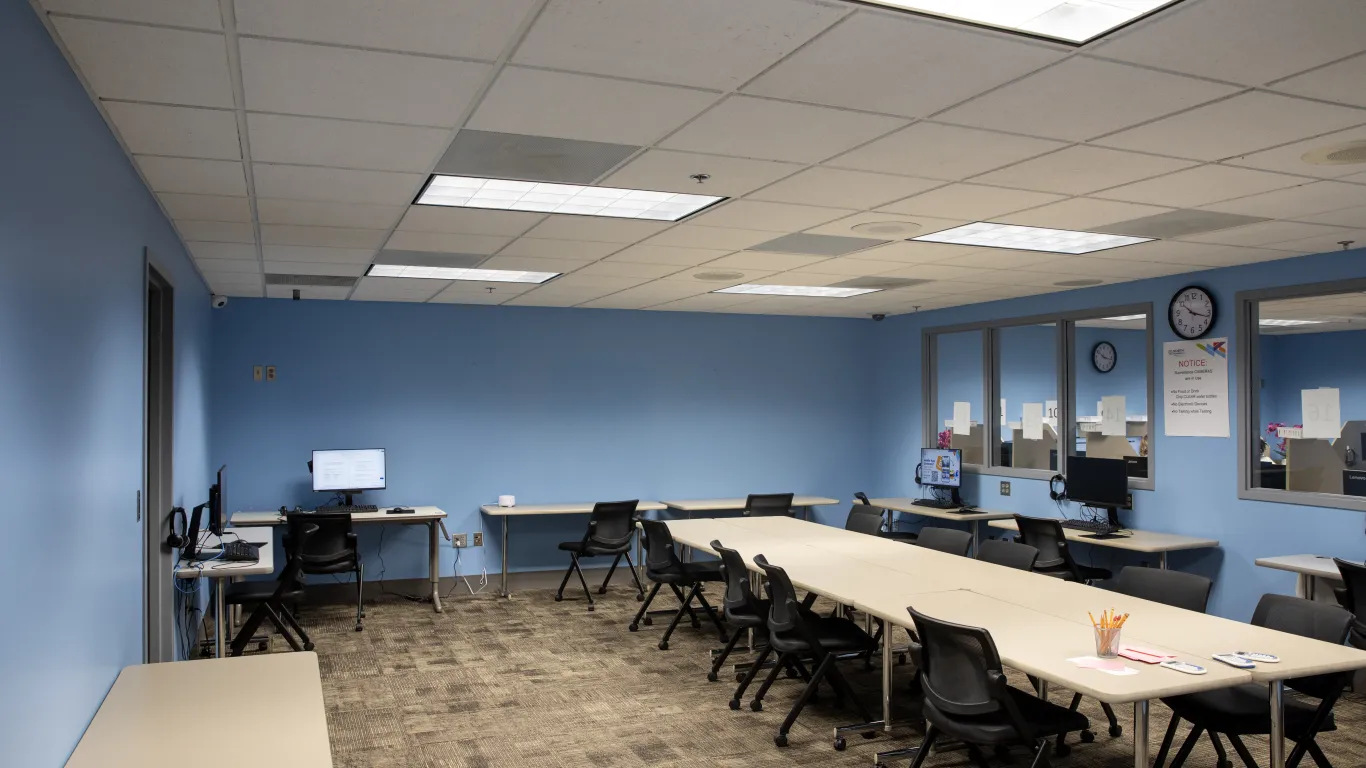 a room with a big table and small tables with computers