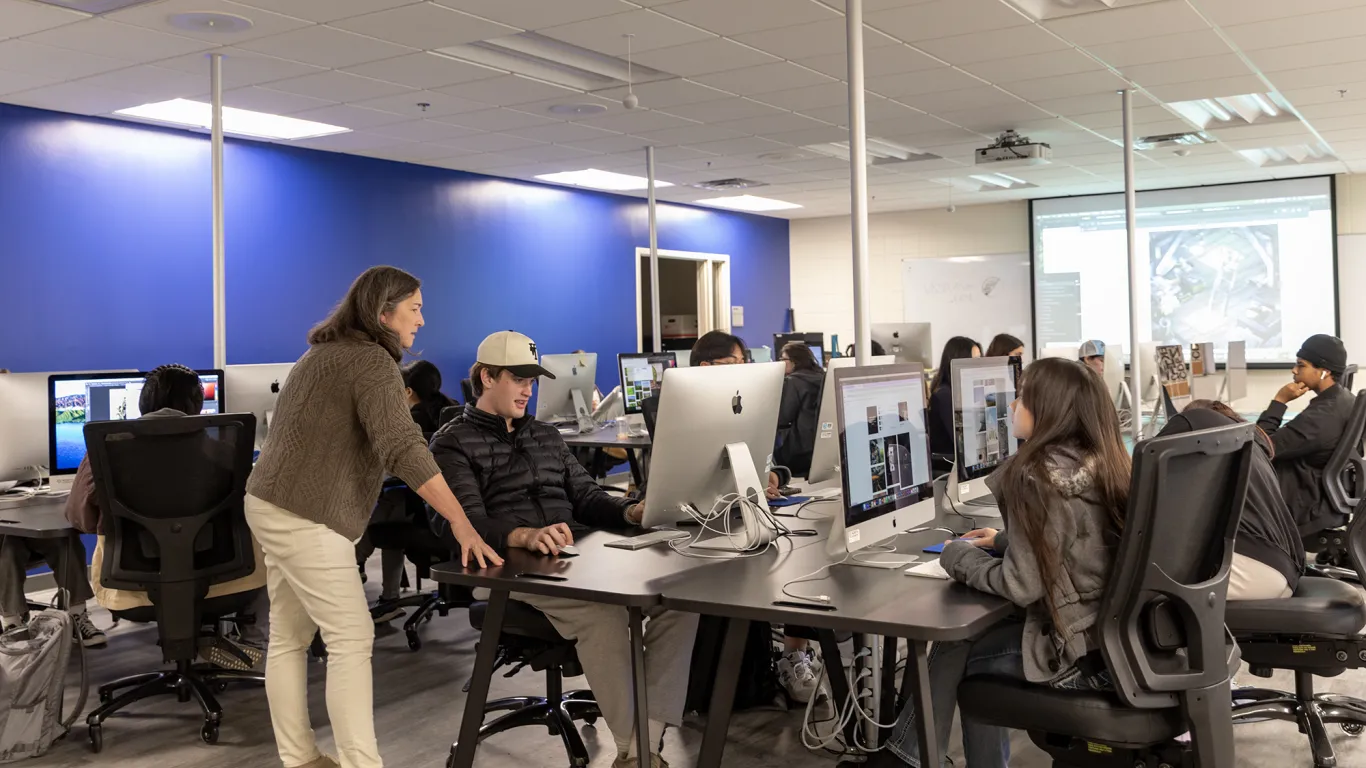 student sitting a computer talking with an instructor