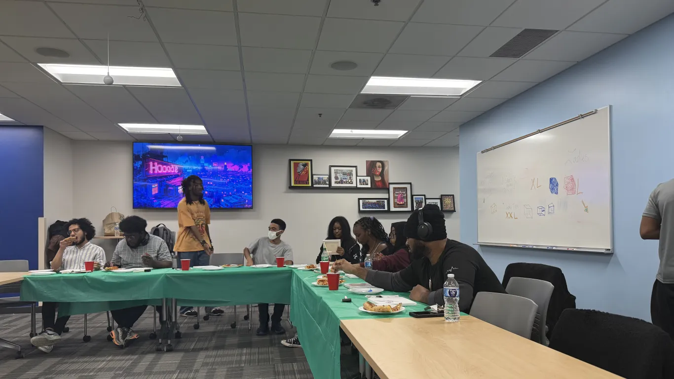 students in a meeting eating Pizza