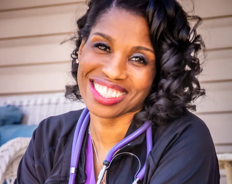 woman smiling wearing nursing uniform 