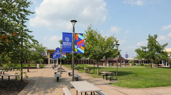 Campus courtyard with picnic tables and branded banners