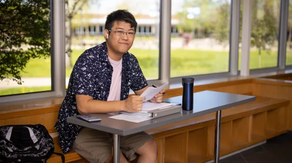 male student sitting and working at desk