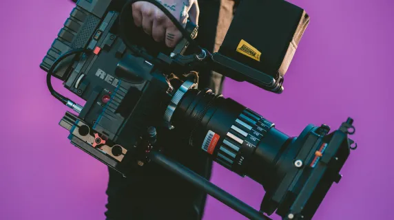 A person holding a film camera at their side