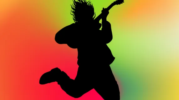 An image of a man in silhouette playing electric guitar against a colorful background.