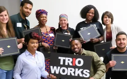 students smiling holding a sign that says trio works 