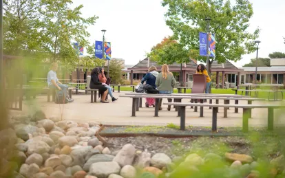 students sitting in the courtyard in the fall 