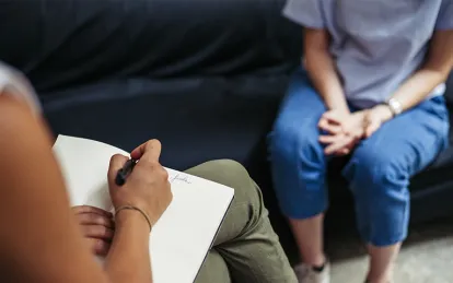 woman sitting on couch sitting across from a woman sitting in a chair 