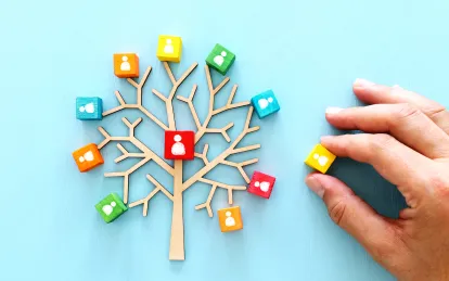 image of a tree with colorful blocks and a hand reaching for them 