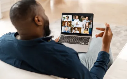 man on a laptop speaking to people on laptop 