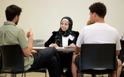 student speaking with two employers at internship fair