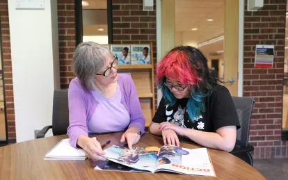 career services staff sitting at a table speaking with student